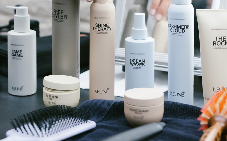 A professional KEUNE styling range arranged beside salon tools